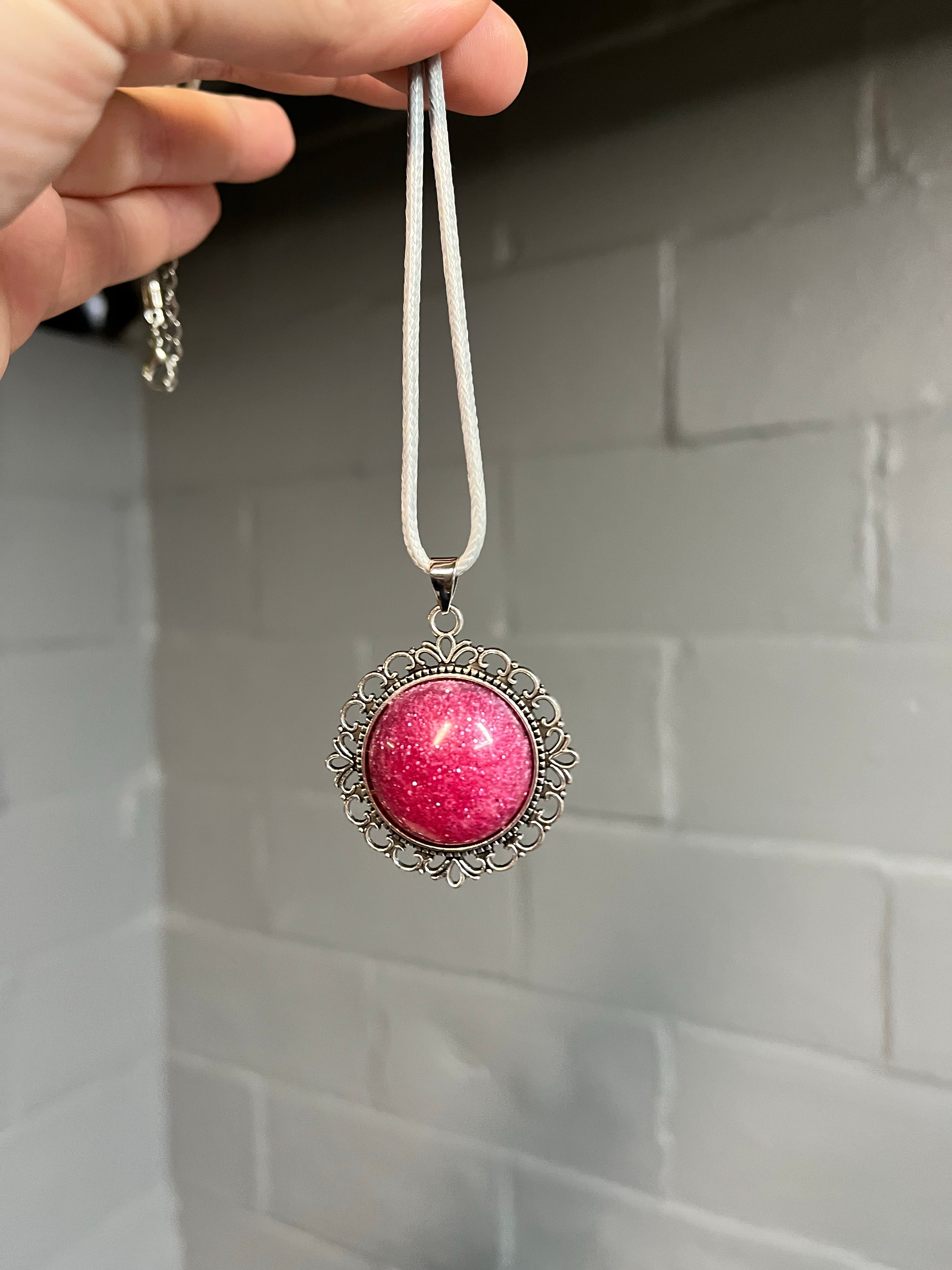 Pink glitter cabochon on silver pendant tray