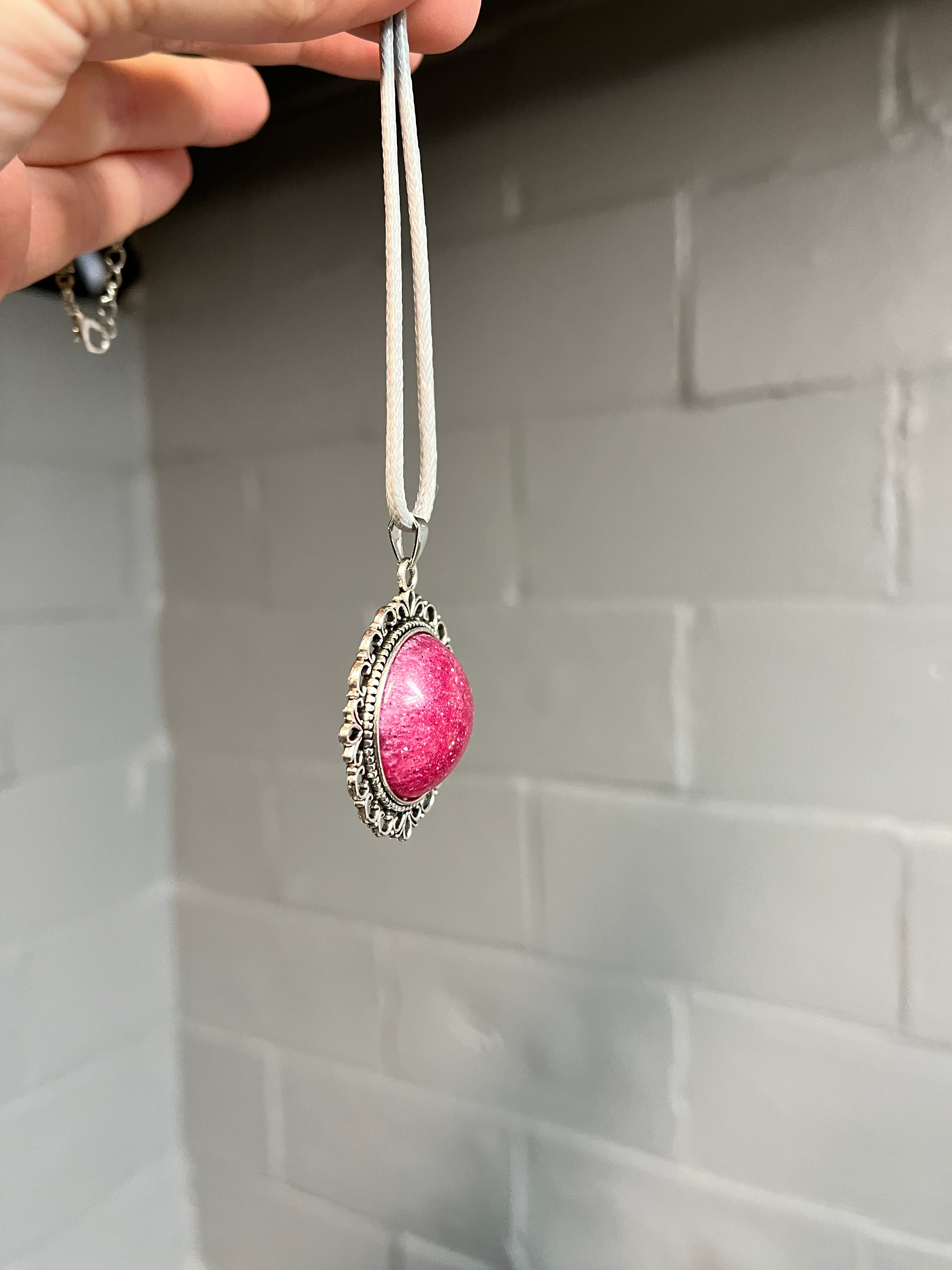 Pink glitter cabochon on silver pendant tray